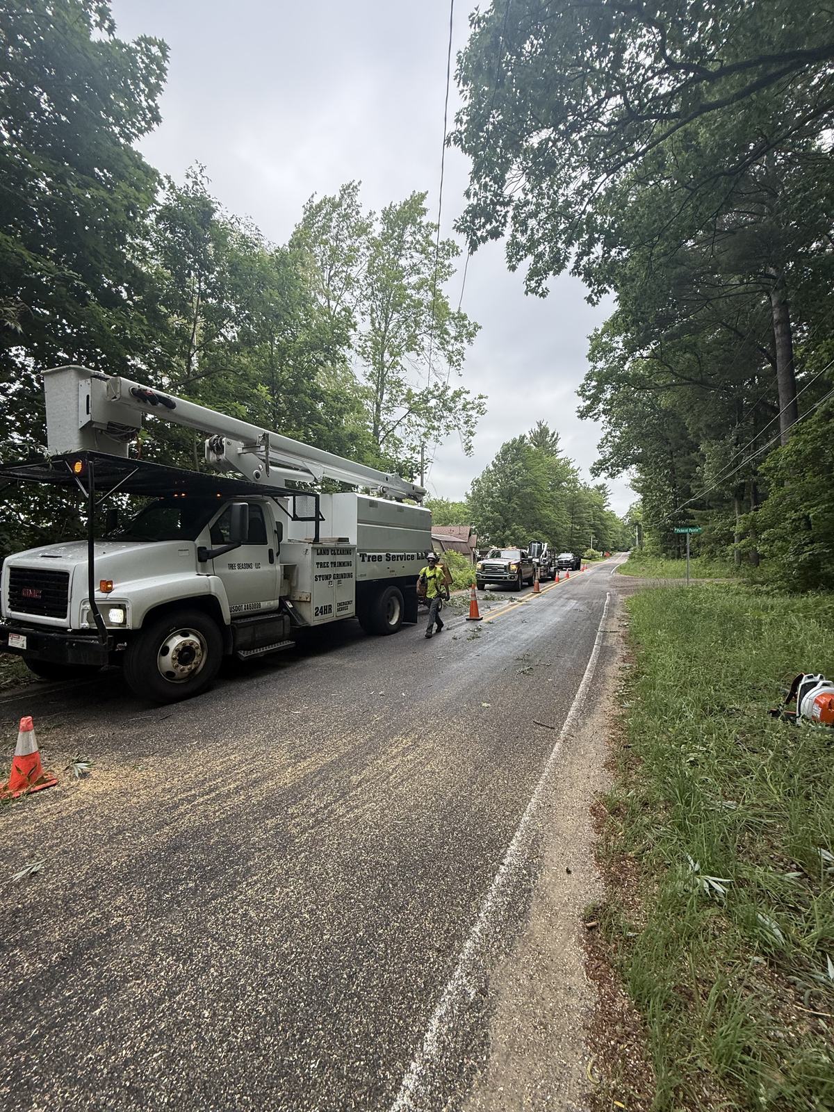 Tree Seasons Arbor Care crew and bucket truck removing storm-damaged trees near power lines in Big Rapids, Michigan